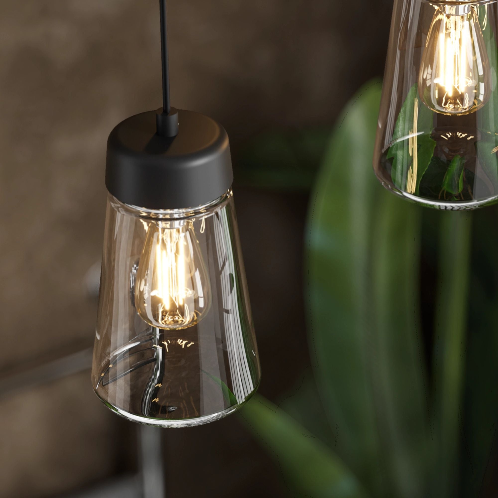 Hib summit pendant lights with clear glass shades and black bases against a blurred background