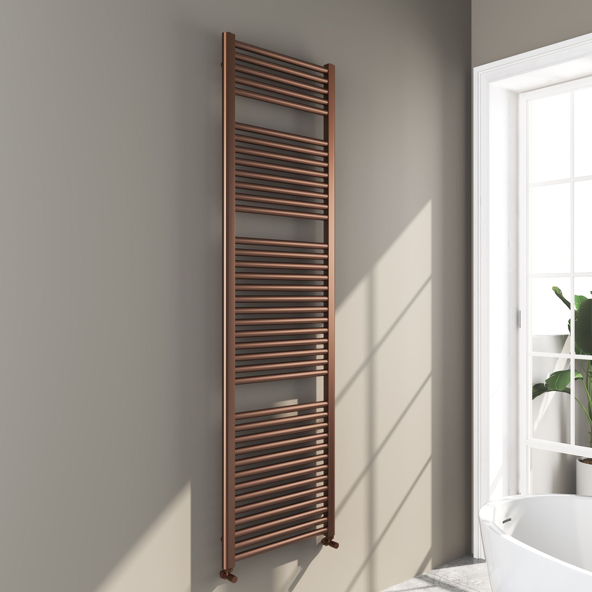 Soho brushed bronze 1800x500mm towel radiator on a gray wall with a window in the background deluxe bathrooms