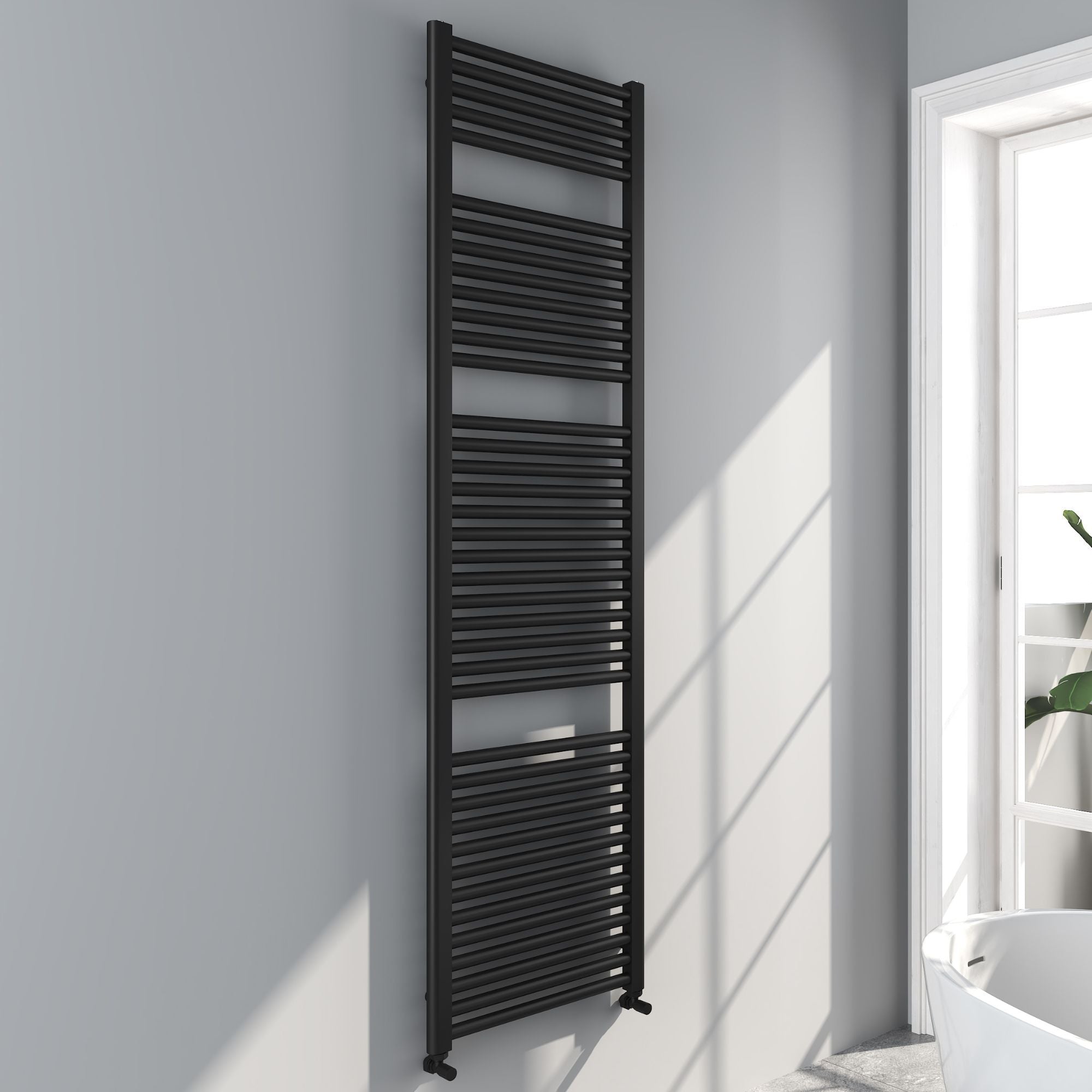 Soho matt black 1800x500mm towel radiator on a white wall with sunlight casting shadows deluxe bathrooms