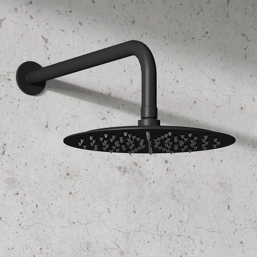 Black shower head with arm mounted on a concrete wall at deluxe bathrooms Ireland