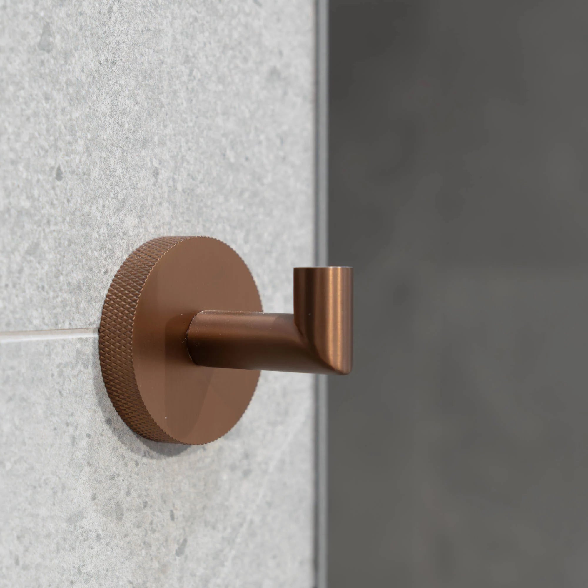 Brushed bronze portofino knurled robe hook on a textured wall deluxe bathrooms