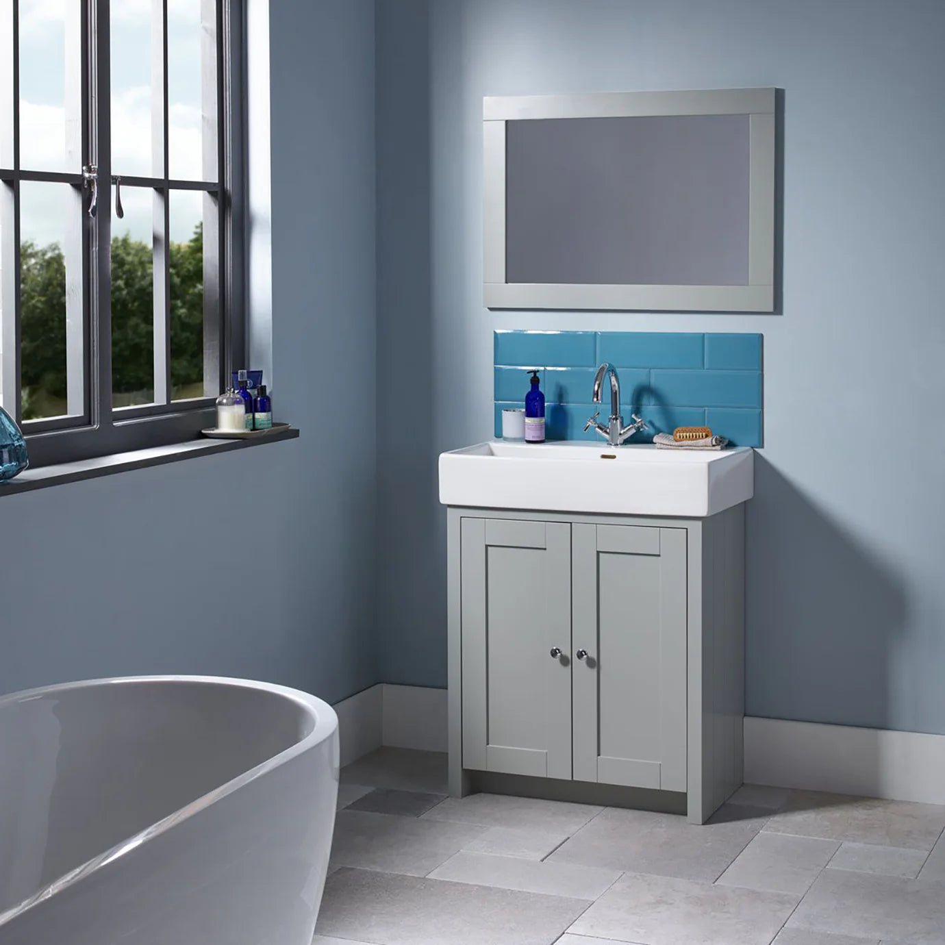 Tavistock lansdown bathroom with grey vanity, white sink, and blue tiled wall deluxe bathrooms